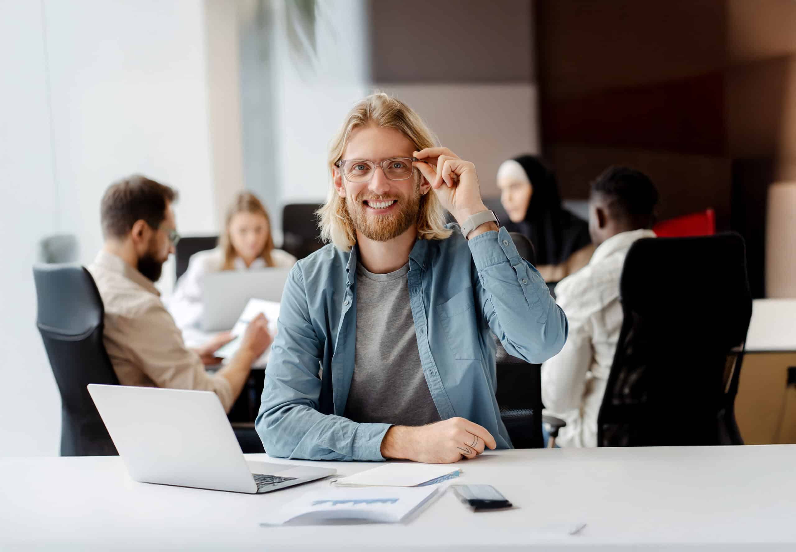 Workshop pendant lequel des étudiants suivent une formation en collaborant ensemble, élève souriant assis avec son pc entrain de s'initier aux outils indispensables pour un data analyst.