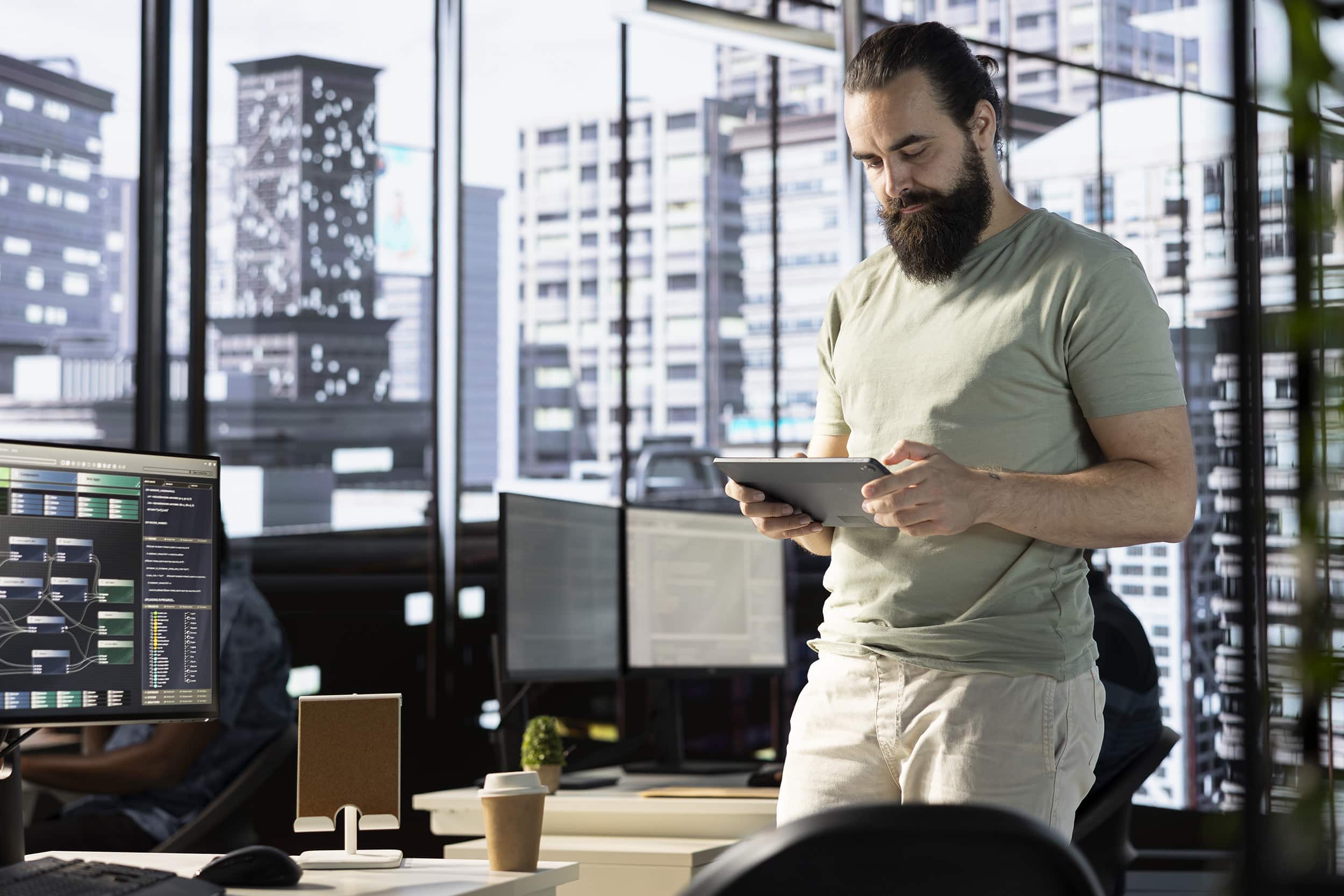 La vie d’un ingénieur en machine learning analysant des résultats de modèles sur tablette dans un open space moderne, entouré d’écrans affichant des flux de données.