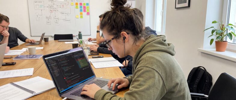 Une femme travaillant sur un ordinateur portable lors d'une formation en informatique.