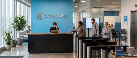 À l'intérieur des bureaux de Snowflake, présentant l'espace de réception où des collaborateurs échangent au comptoir d'accueil.