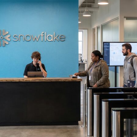 À l'intérieur des bureaux de Snowflake, présentant l'espace de réception où des collaborateurs échangent au comptoir d'accueil.