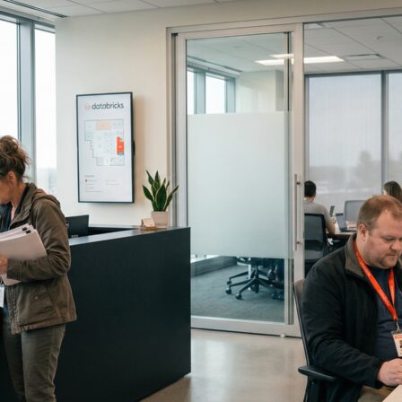 Ein moderner Bürobereich bei Databricks, in dem Mitarbeitende an ihren Schreibtischen arbeiten, mit Fokus auf Teamarbeit und Technologie.
